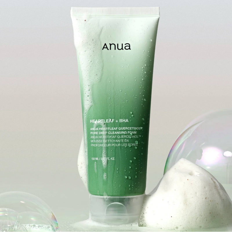Green tube of Anua skincare product with bubbles on a light gray background