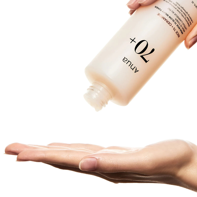 Bottle of Anue 70+ cream being applied to a hand on a white background