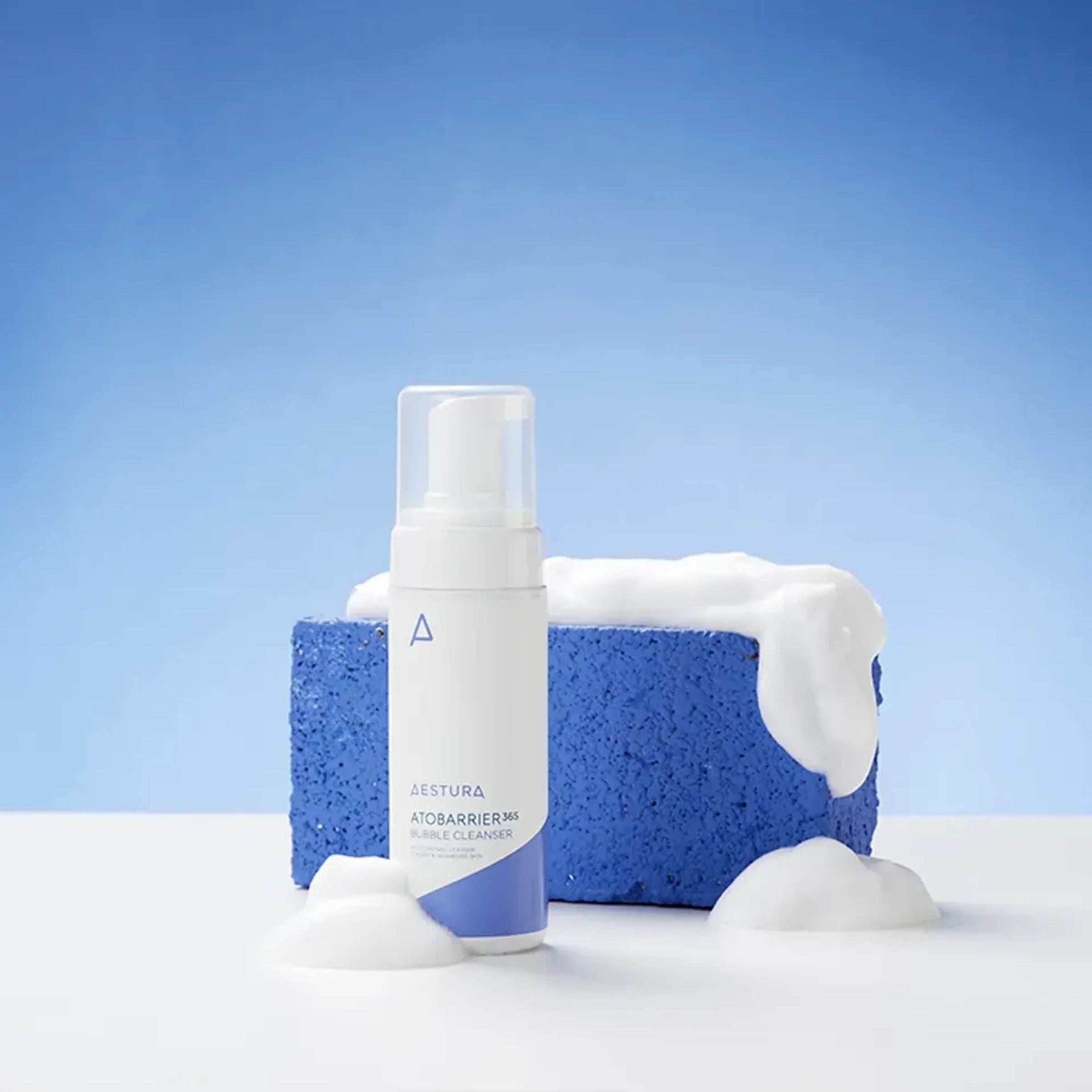 Skincare product with a blue sponge and foam on a light blue background