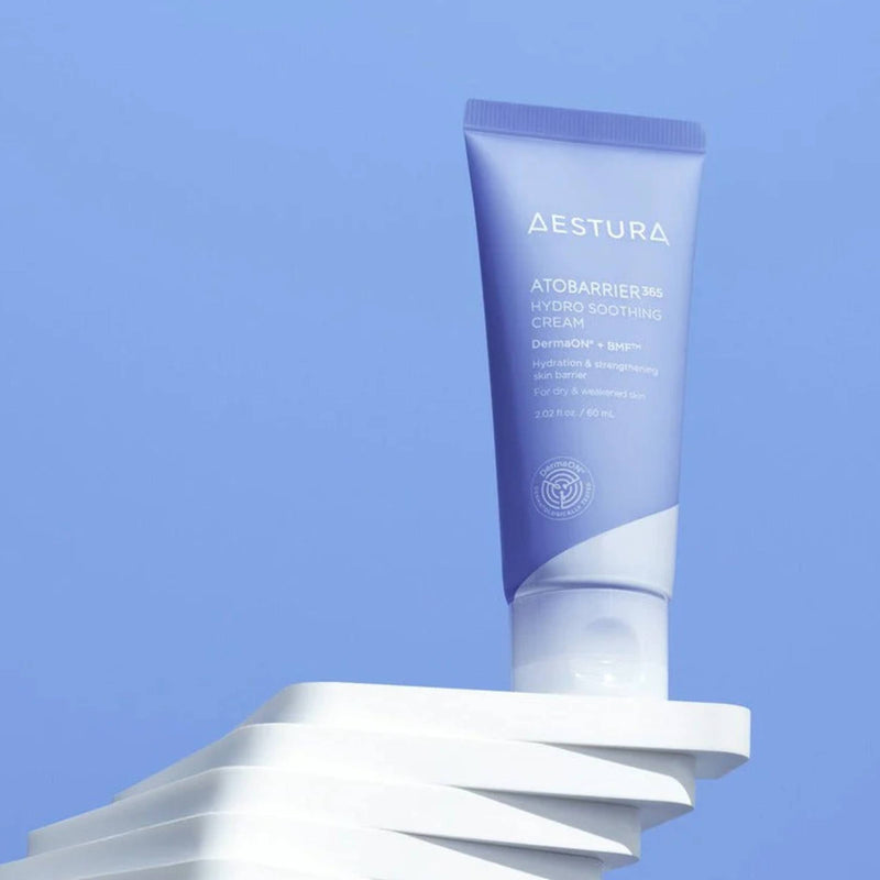 Aestura soothing cream tube on a white platform with a blue background