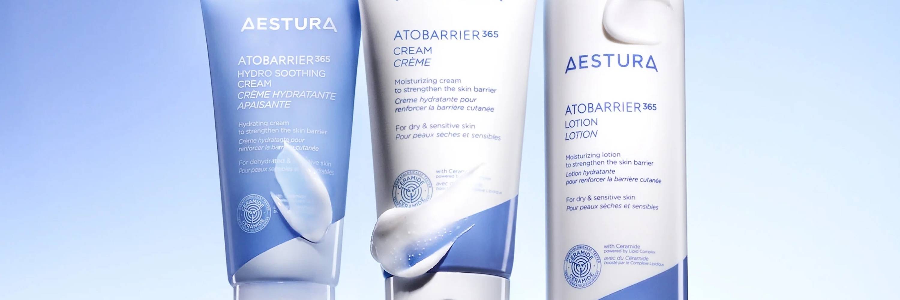 Three Aestura skincare products on a light blue background