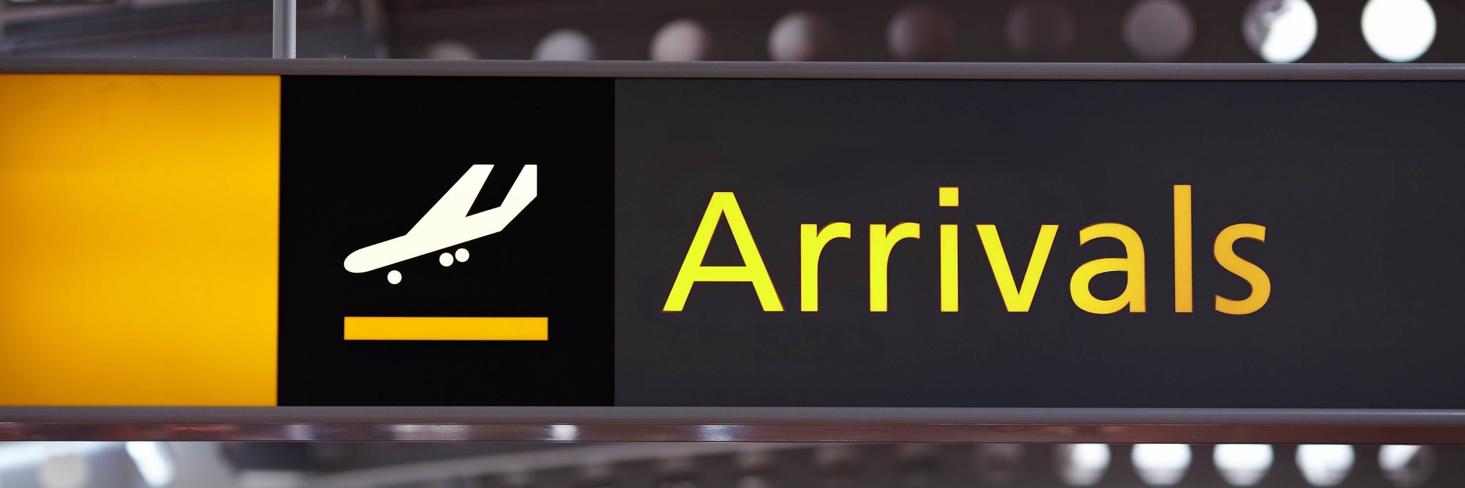 Arrivals sign with airplane icon on a black background