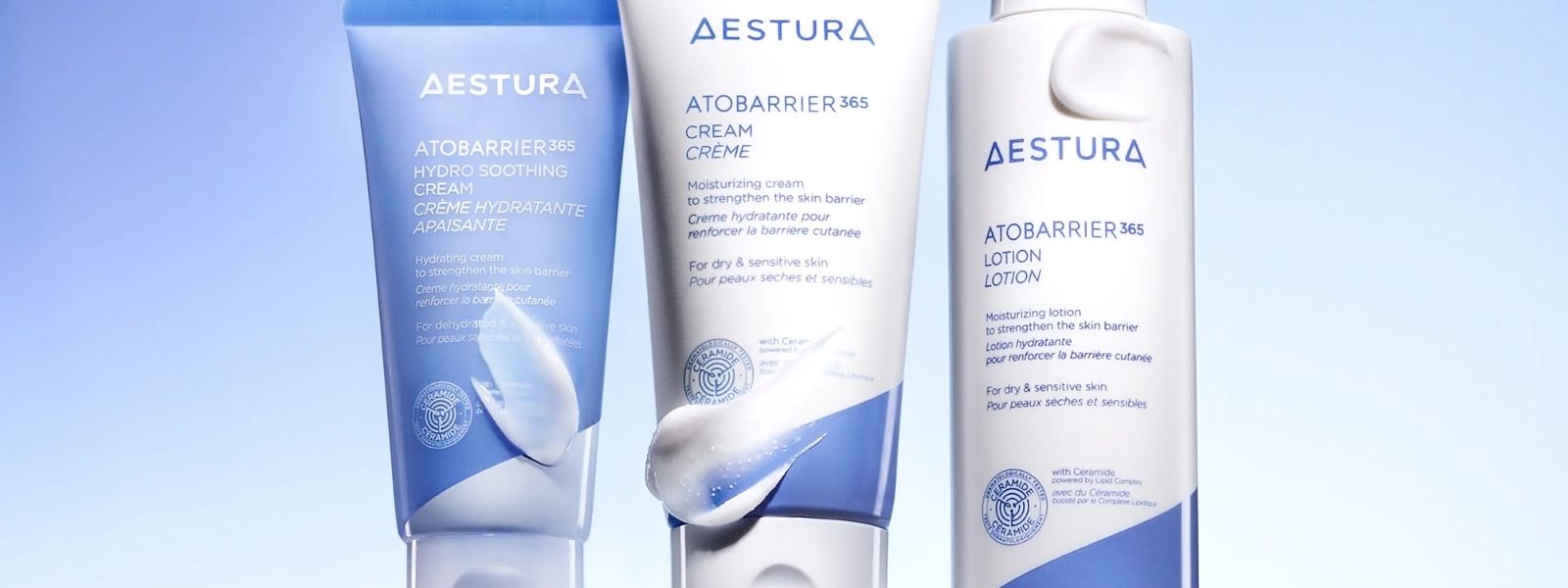 Three Aestura skincare products on a light blue background