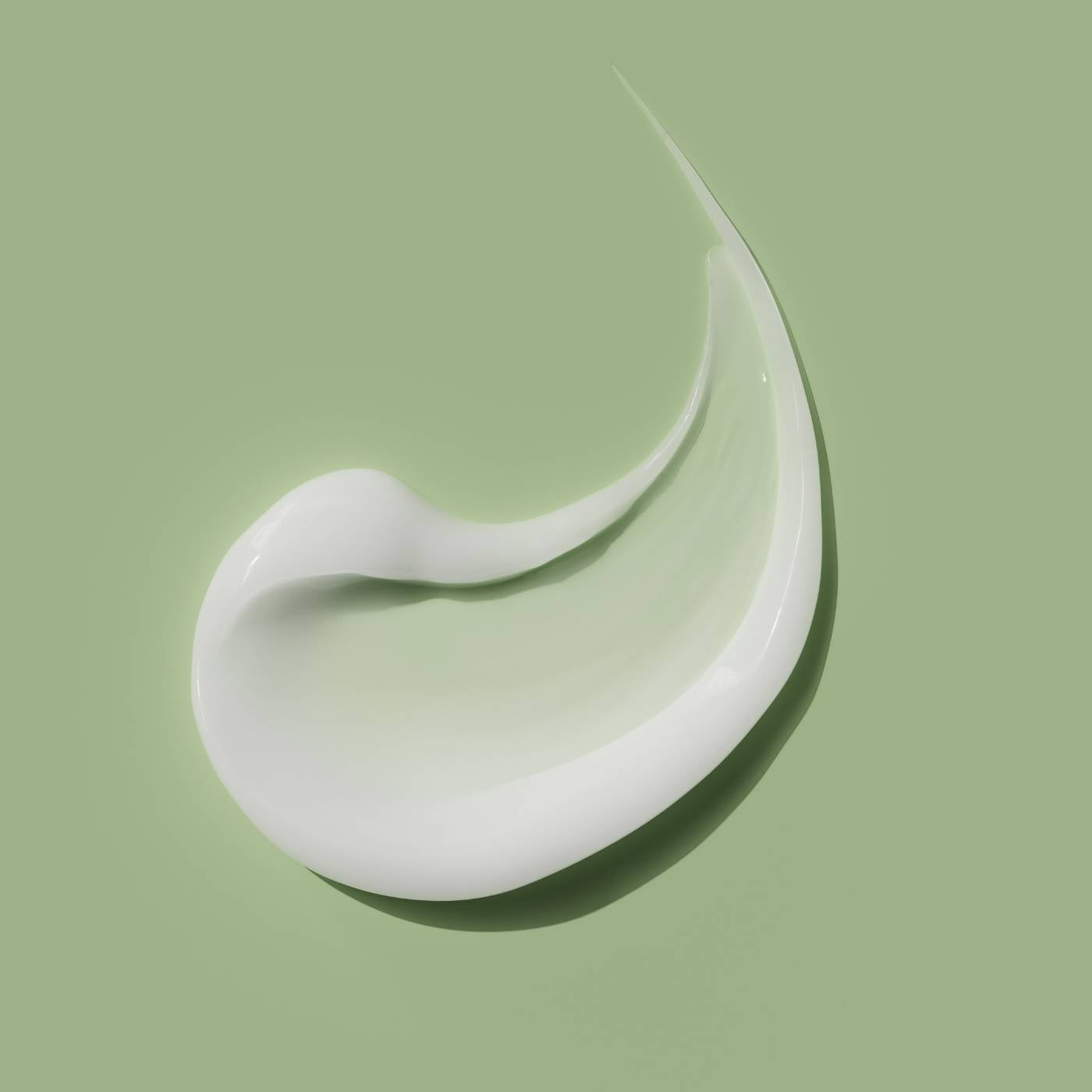 White skin booster cream in a curved shape on a green background