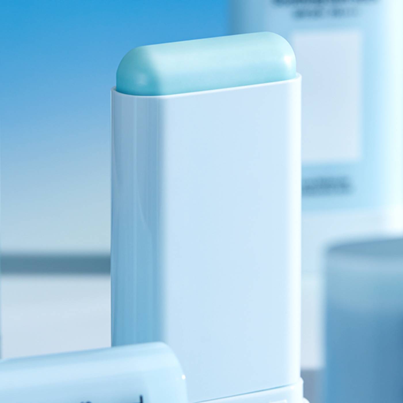 Suncream stick with a blue top on a blurred background