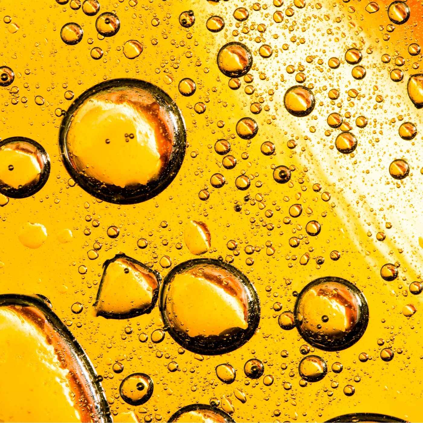 Close-up of oil and water bubbles on a yellow background