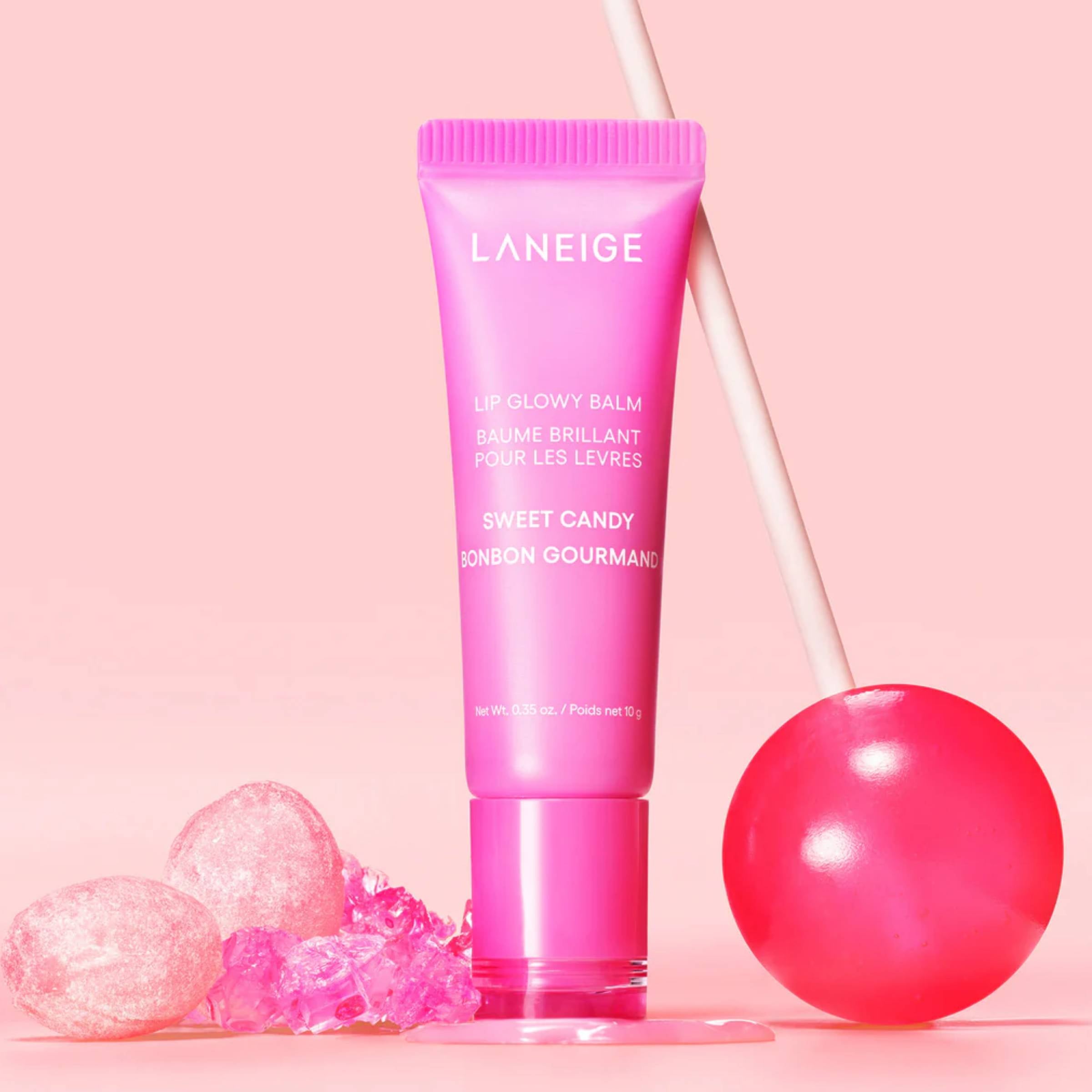 Pink Laneige lip balm tube with candy-themed elements on a pink background
