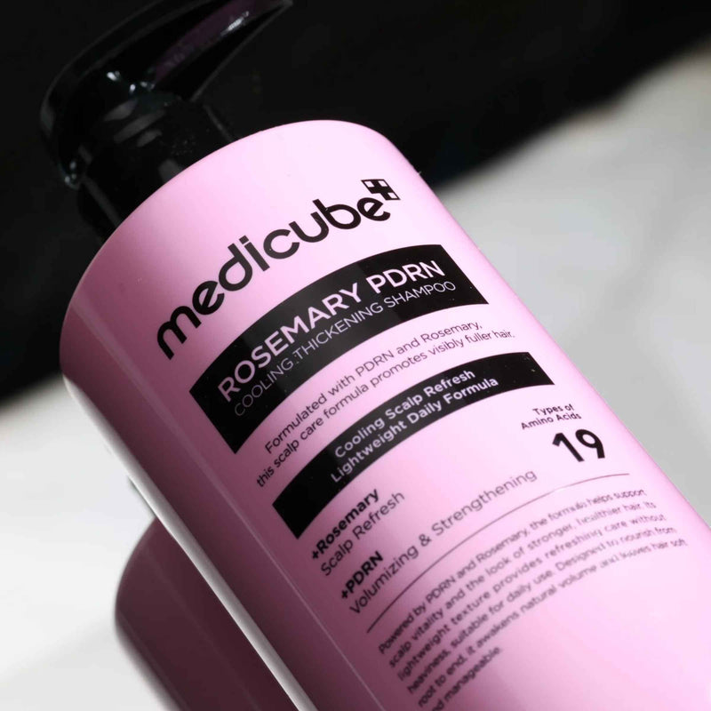 Pink bottle of Medicube Rosemary PDRN Shampoo on a white background