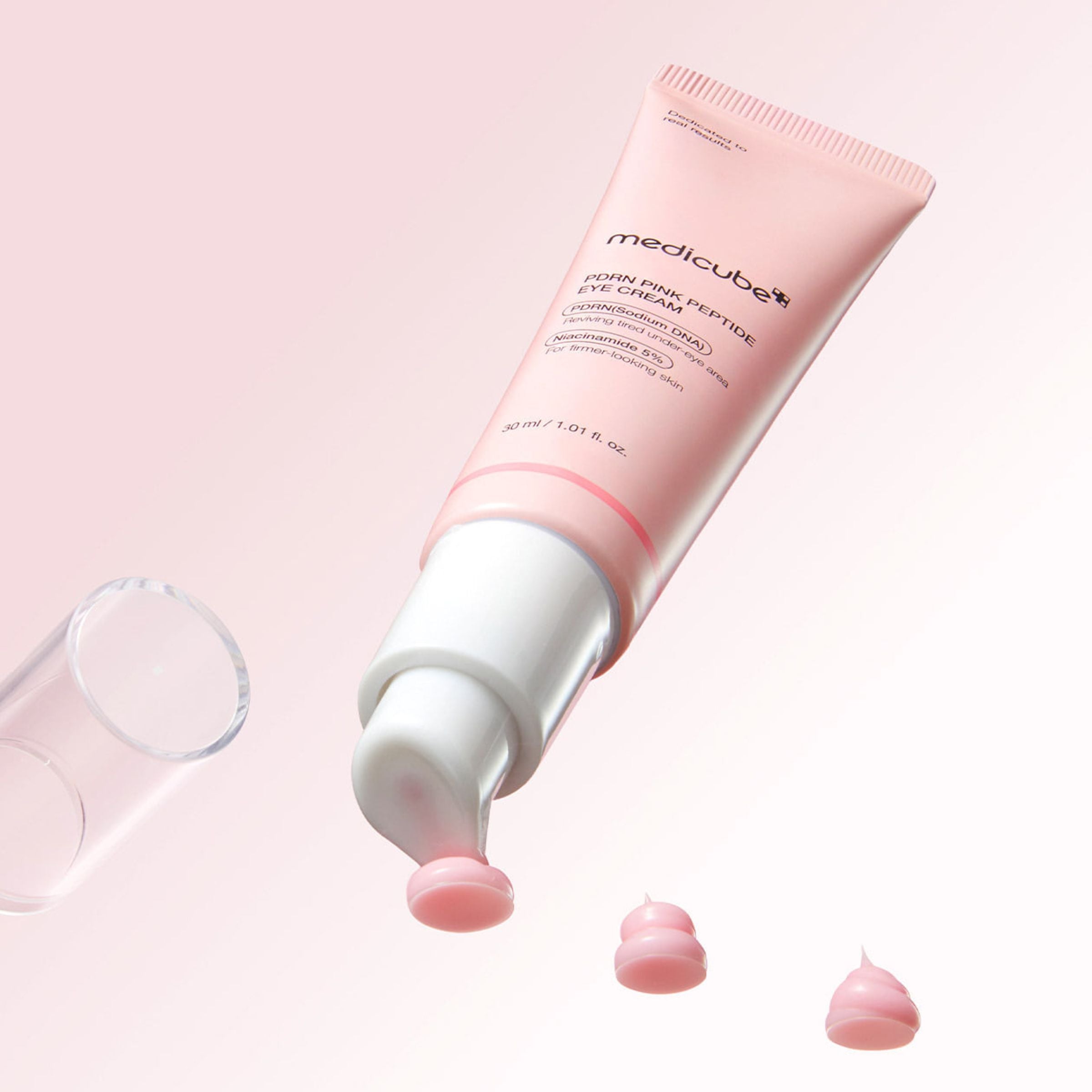 Pink Medicube PDRN eye cream tube with on a light pink background