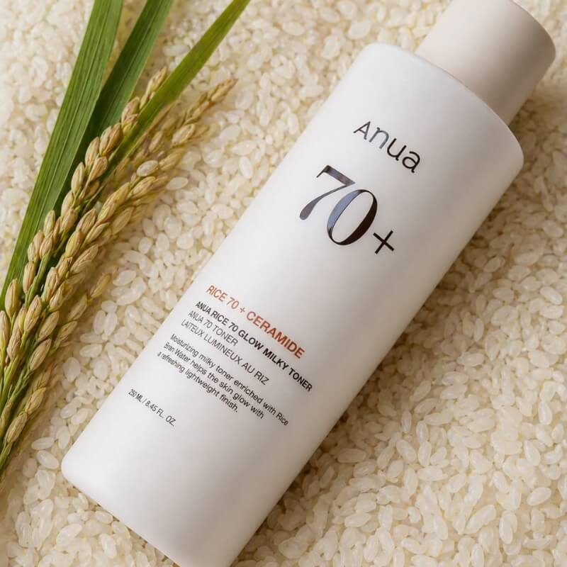 ANUA Rice 70 Glow Milky Toner lying on a bed of rice