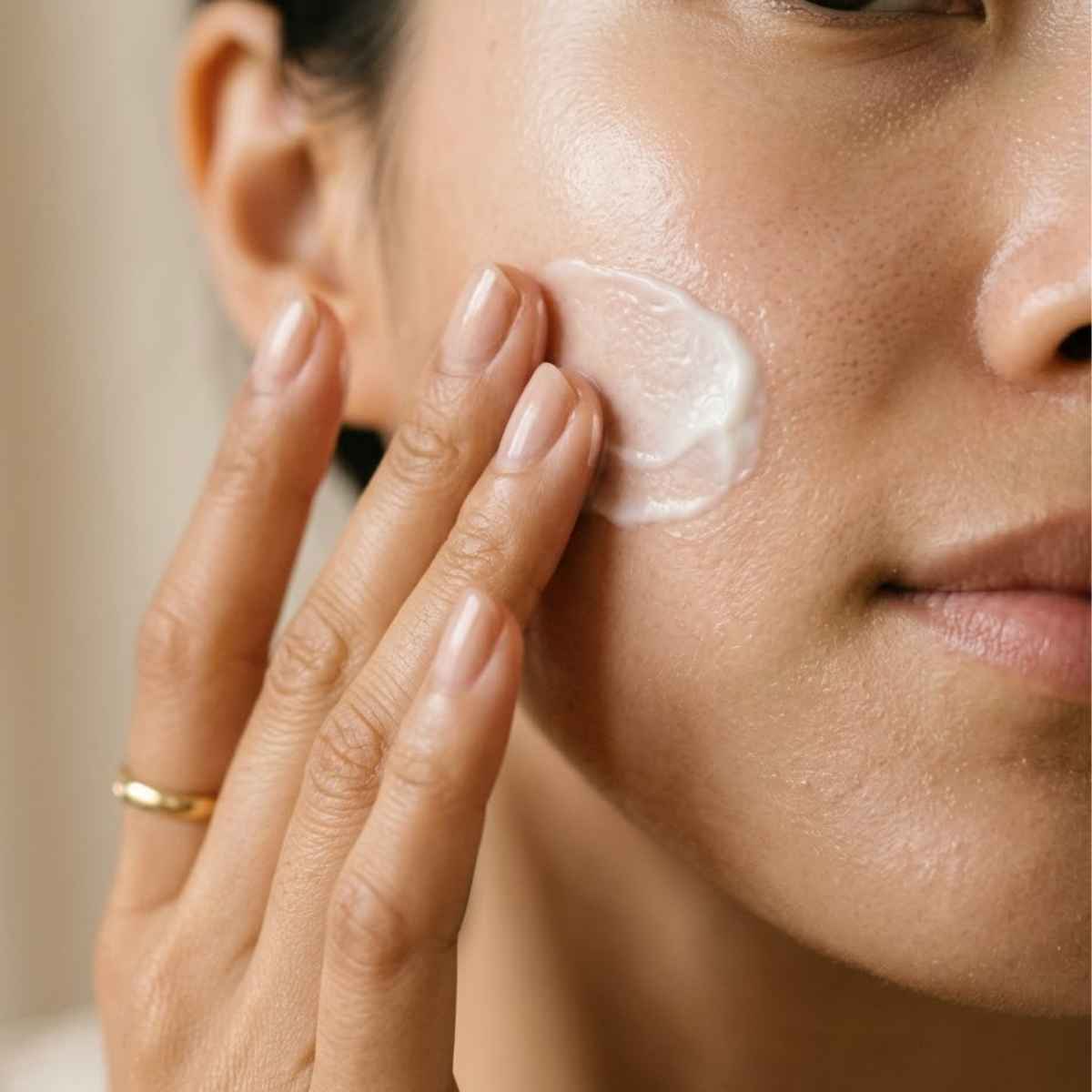Close-up of a person applying cream to their face
