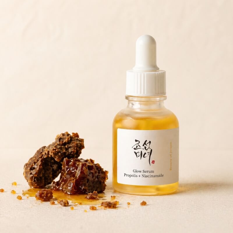 Beauty of Joseon Glow Serum next to propolis against a neutral background