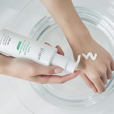 Person applying skincare product to hand with a clear background