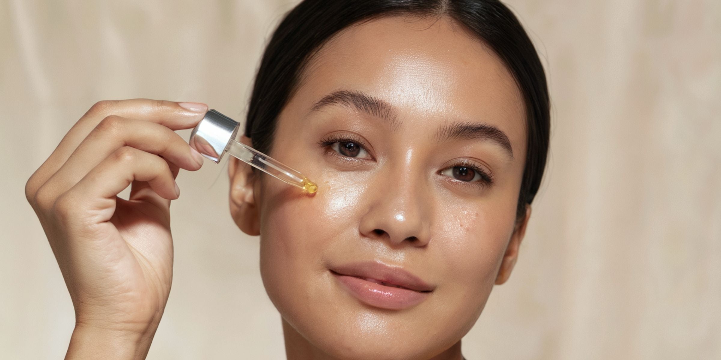 Dropper applying Korean skincare ampoule on face