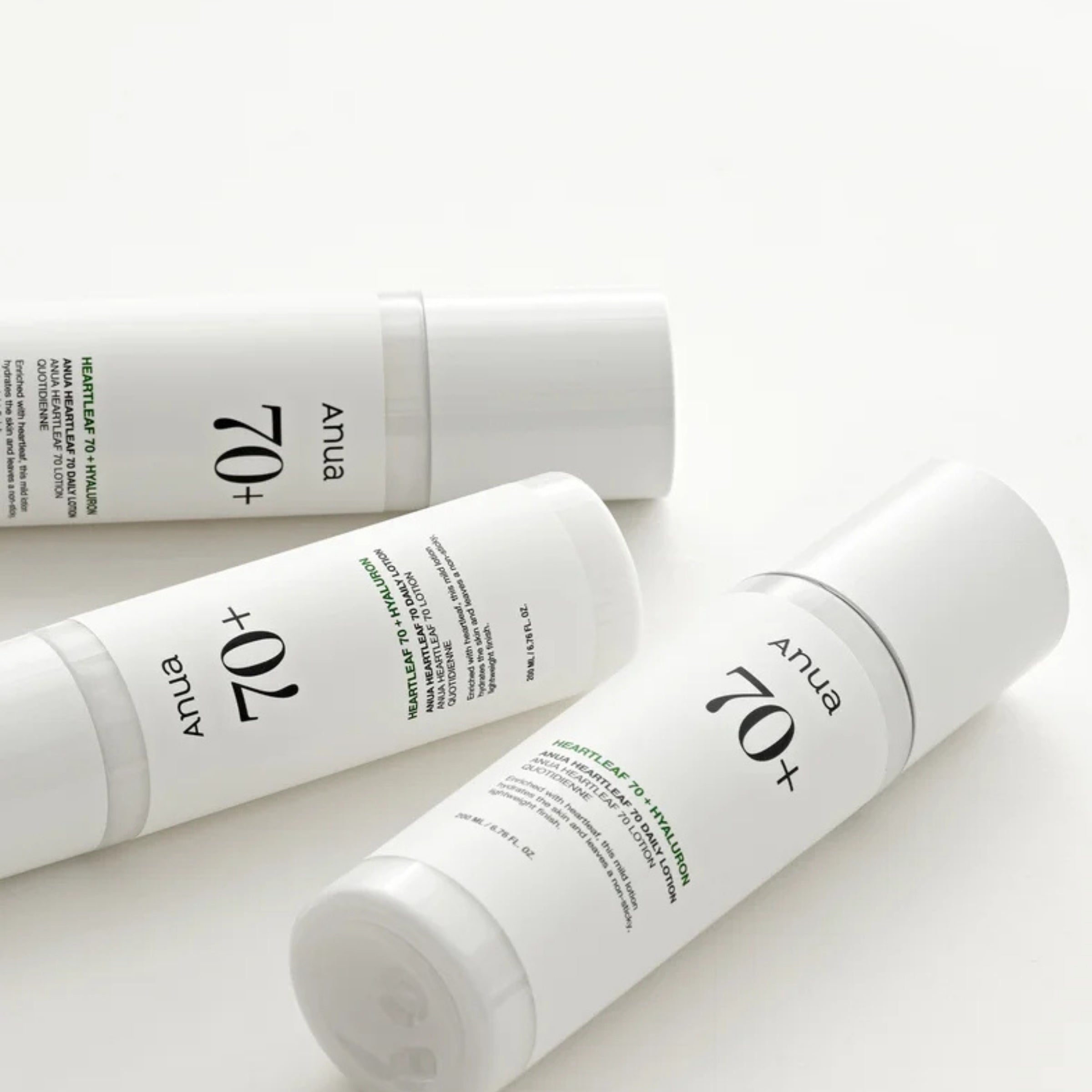 Three white bottles of anua skincare product on a light background