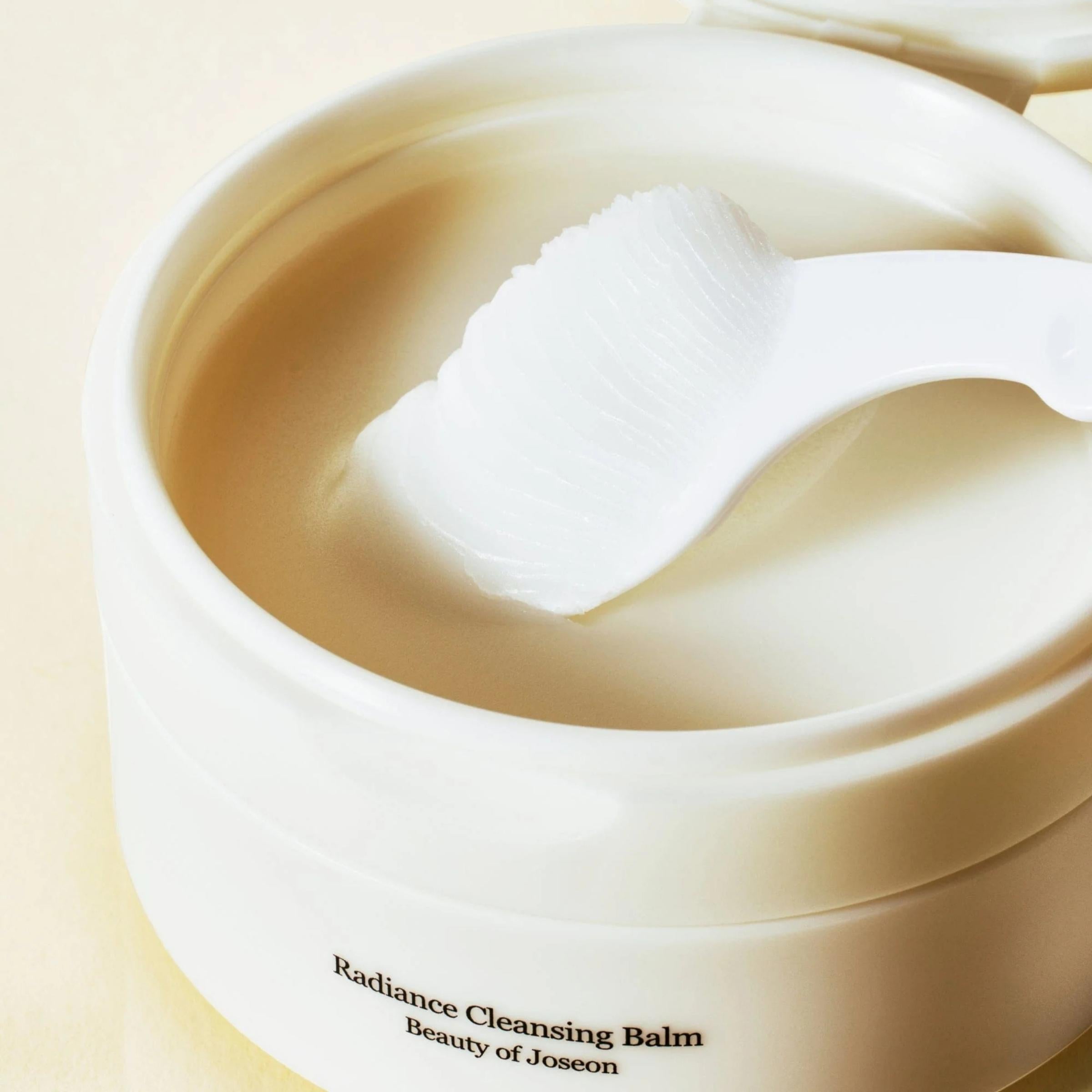 Radiance Cleansing Balm container with a white sponge on a beige background