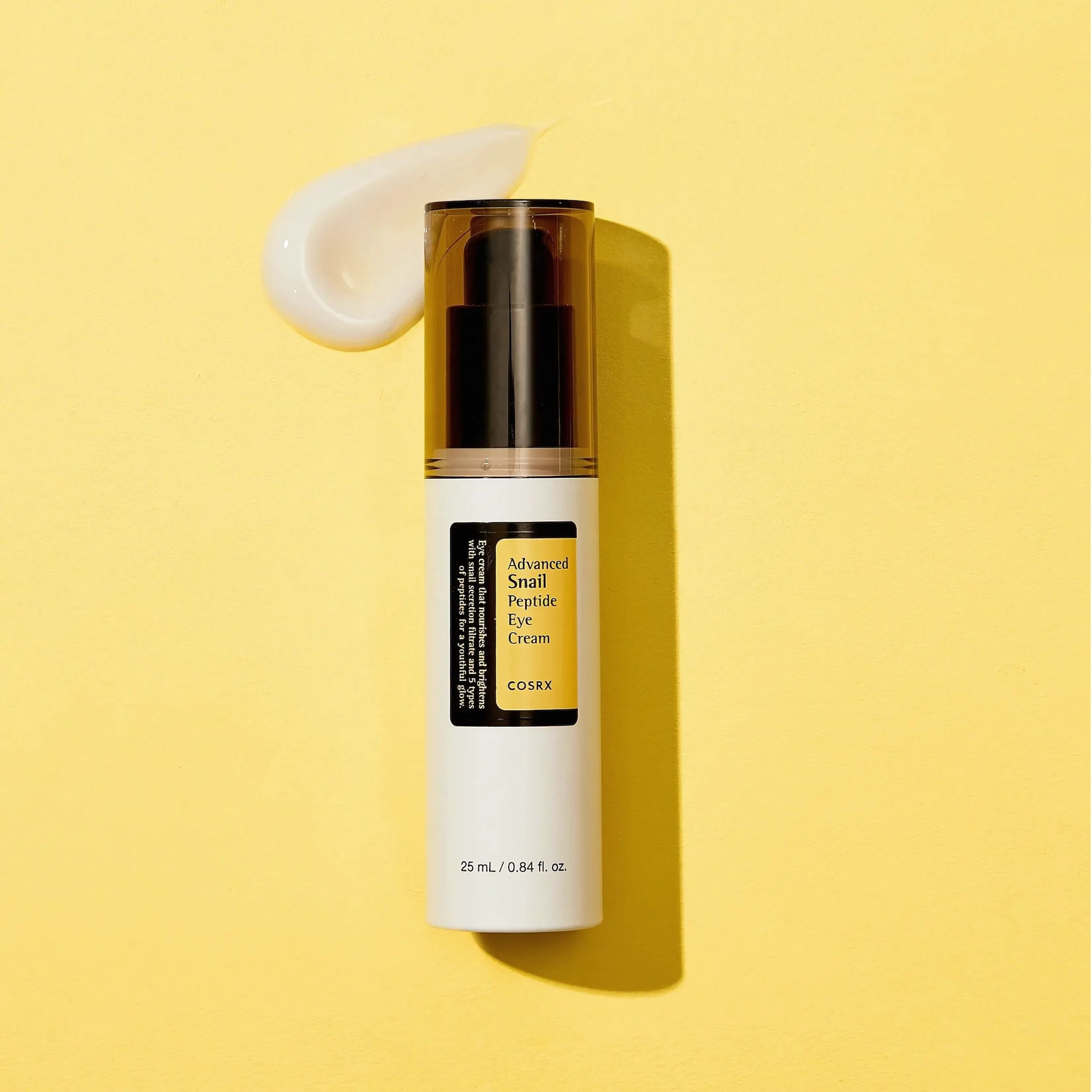 CosRX Advanced Snail Repair Cream bottle with a swatch of cream on a yellow background
