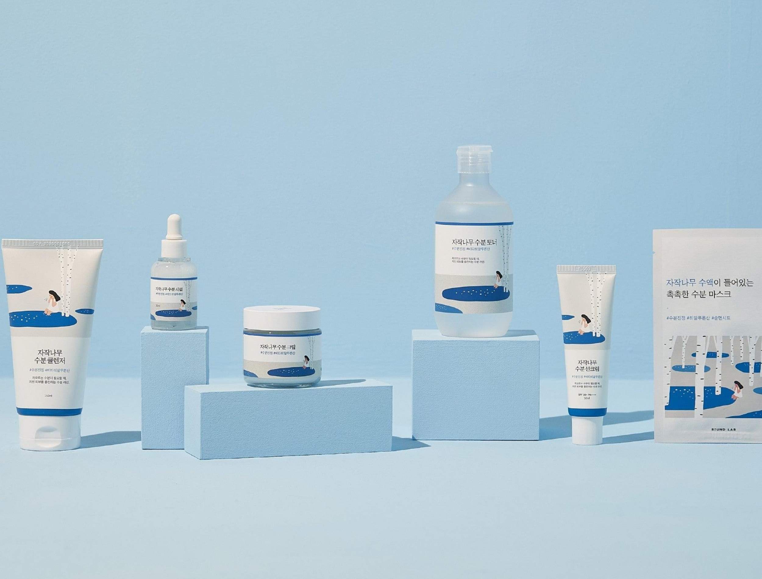 Round Lab skincare products on blue stands with a blue background