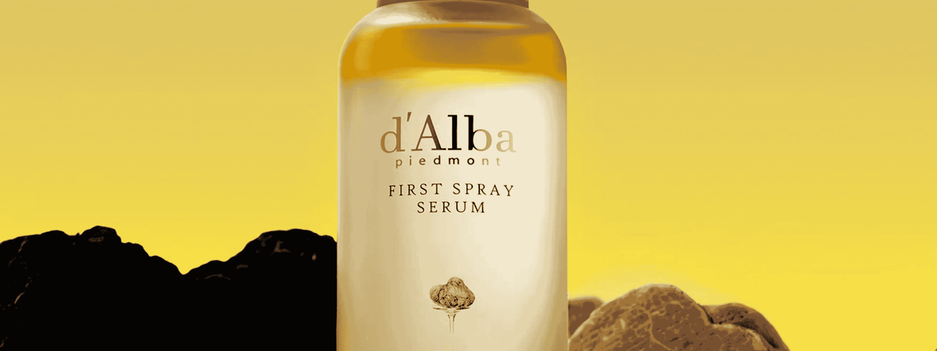 Bottle of d'Alba truffle serum on a yellow background with truffles.