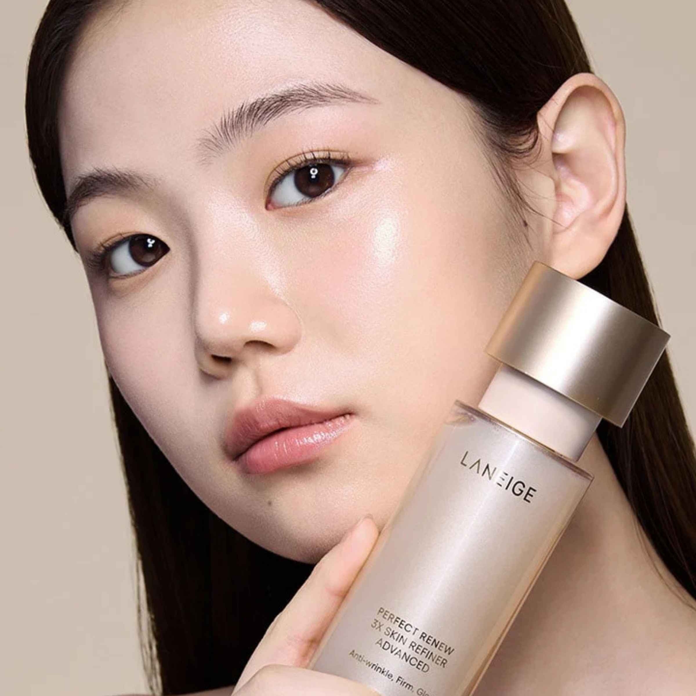 Woman holding a Laneige skincare product against a neutral background