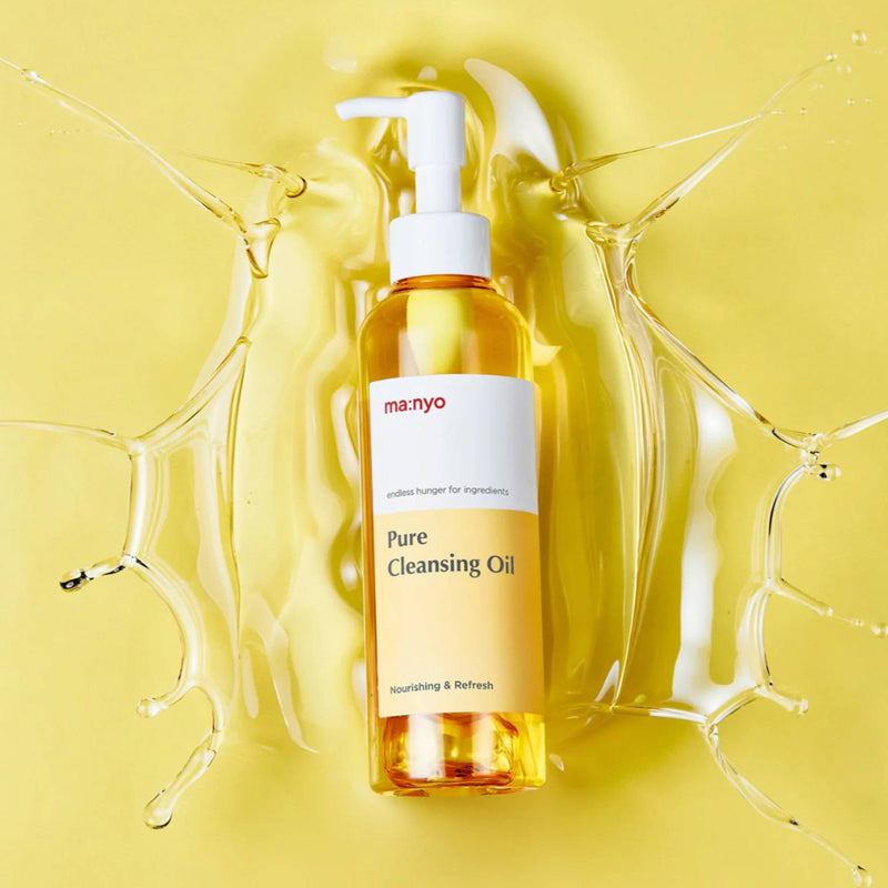 Manyo Pure Cleansing Oil bottle on a yellow background with oil splashes