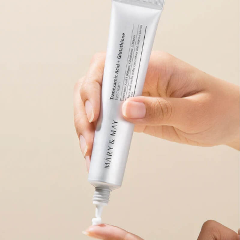Hand holding Mary and May Tranexamic Acid Glutathione Eye Cream with cream texture