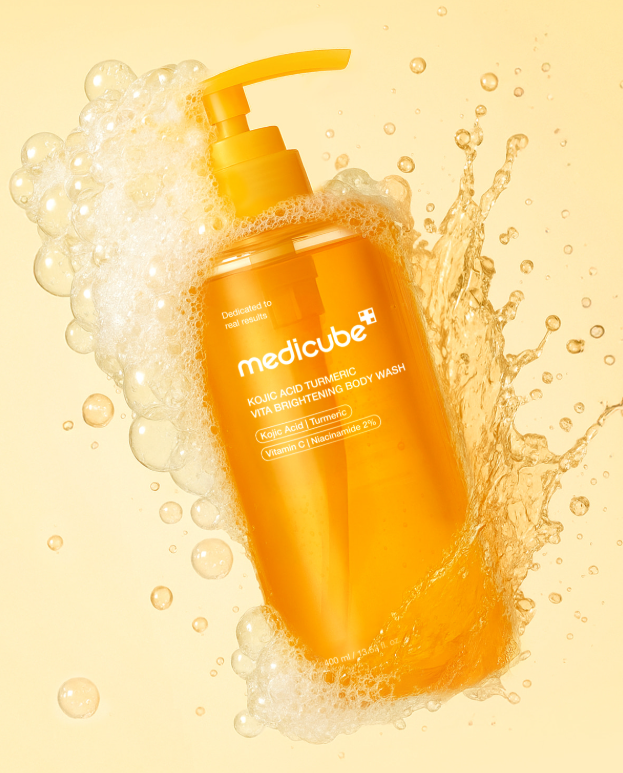 Orange bottle of Medicube body wash with bubbles on a yellow background