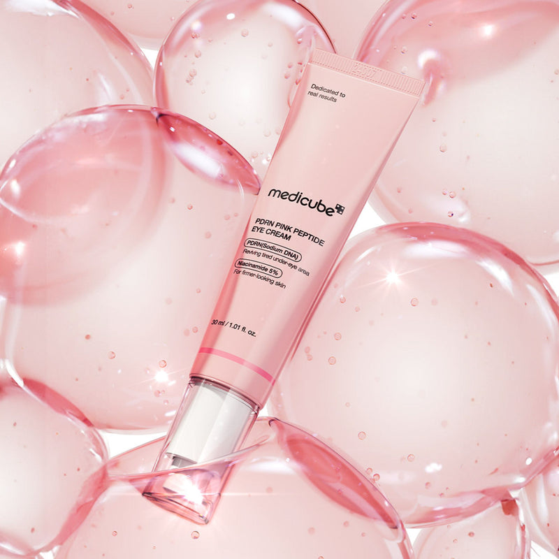 Pink Medicube PDRN eye cream tube on a background of pink gel bubbles