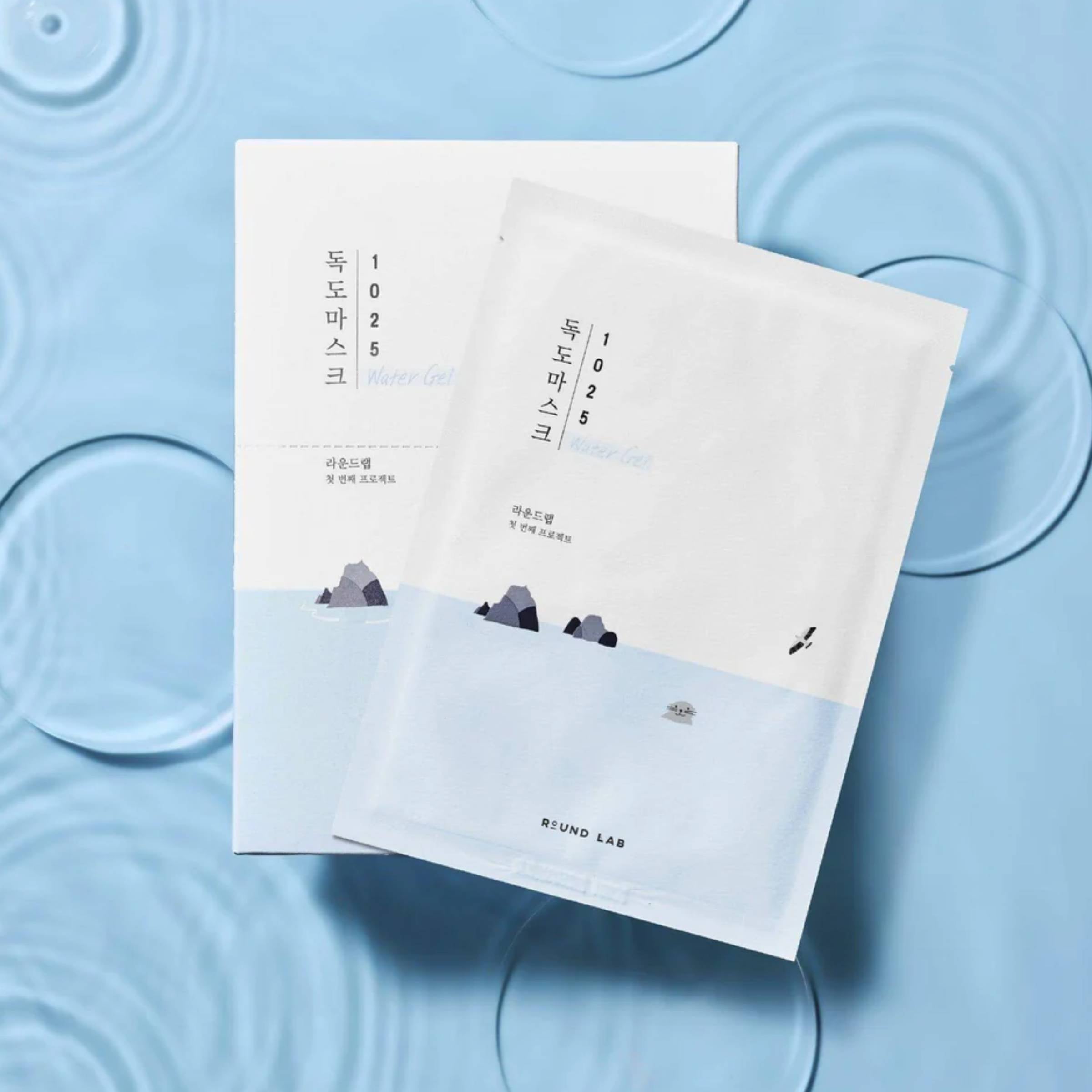 Two white face mask packages on a blue textured background
