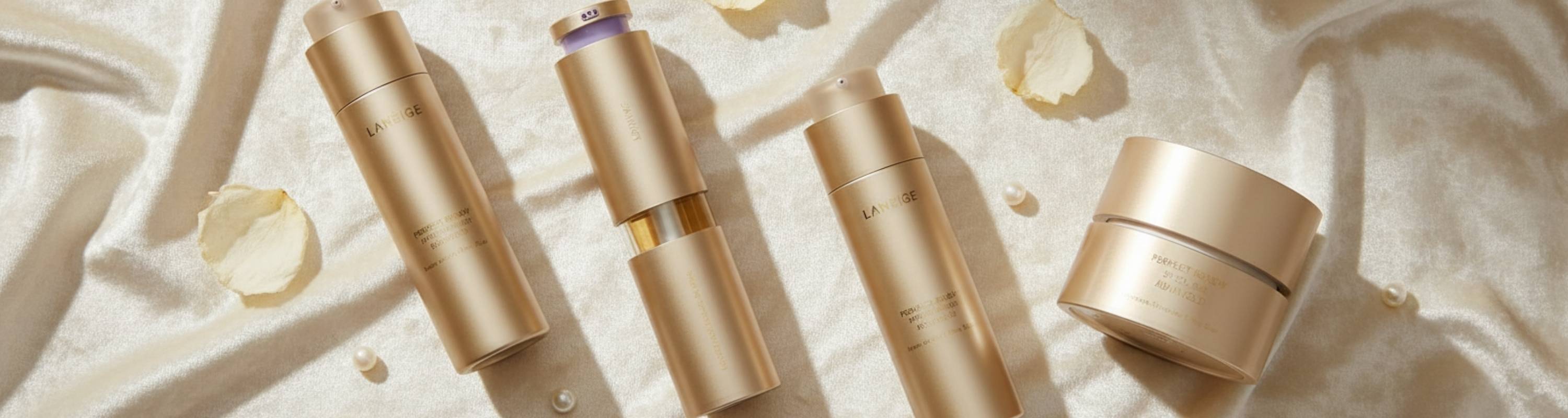 Set of gold cosmetic containers on a textured beige background