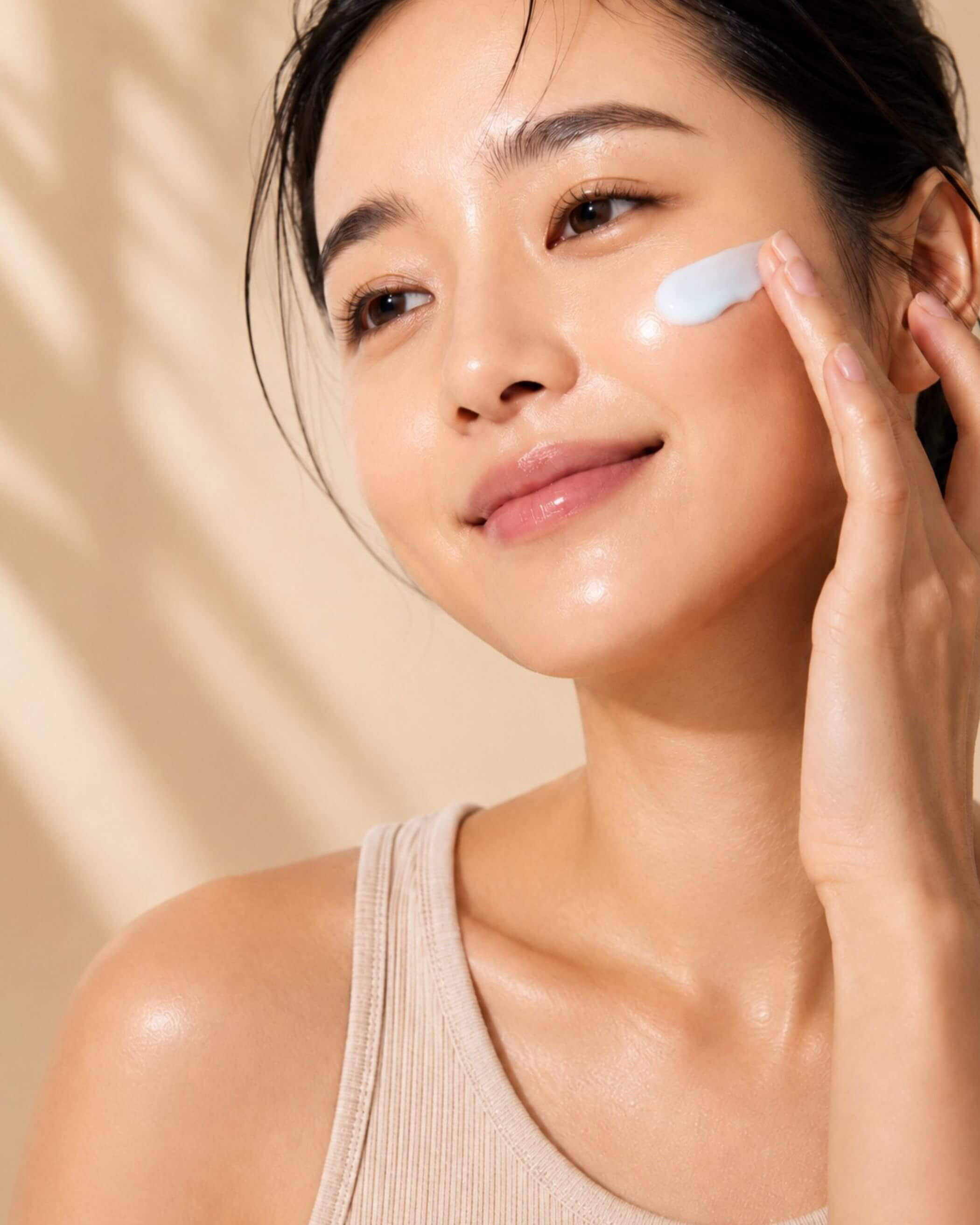 Woman applying Torriden Dive In Soothing Cream to her face with a beige background