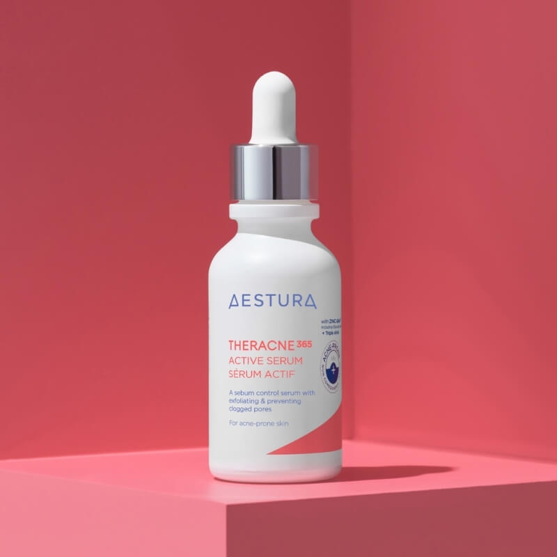 Aestura Theracne 360 active serum bottle on a pink background