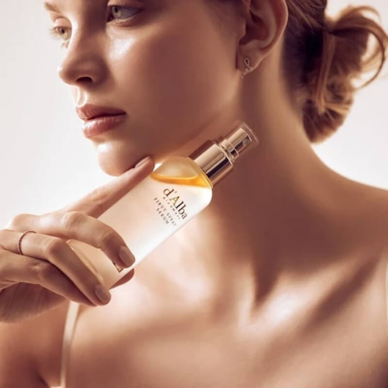 Woman holding a bottle of d'Alba White Truffle First Spray Serum in K-beauty glass skin glow routine