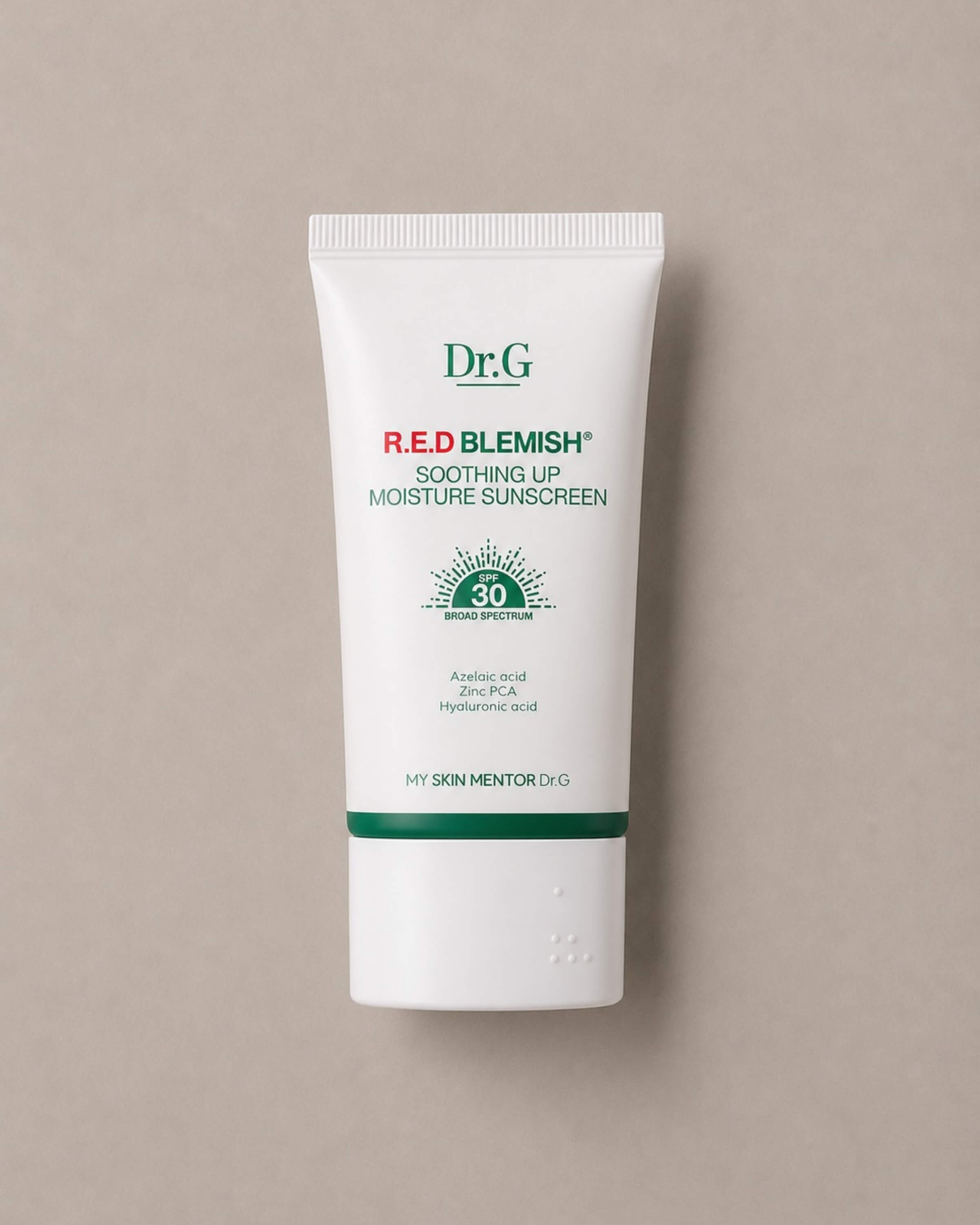 Dr.G Red Blemish Soothing Up Moisture Sunscreen tube on a beige background