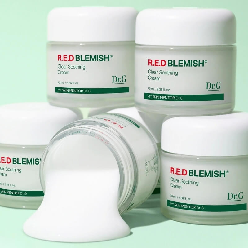 Multiple jars of Dr.G Red Blemish Clear Soothing Cream on a light green background