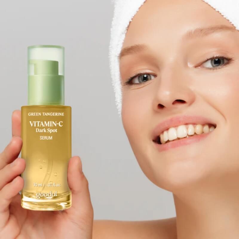 Person holding a bottle of Goodal Green Tangerine Vita C Dark Spot Serum in K-beauty brightening routine