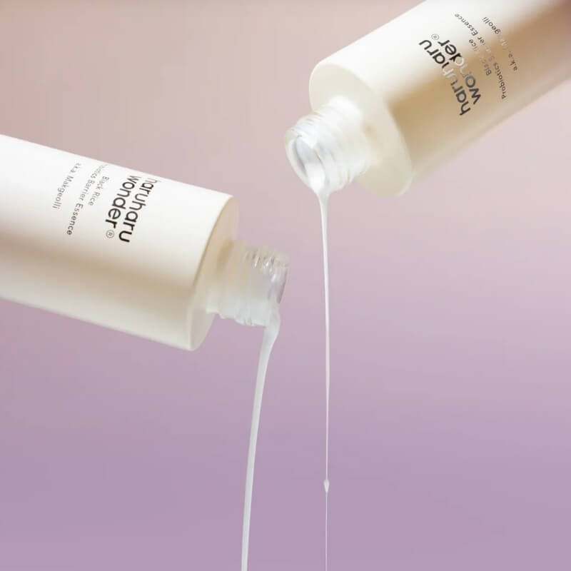 Bottles of Haruharu Black Rice Probiotics Barrier Essence pouring out liquid