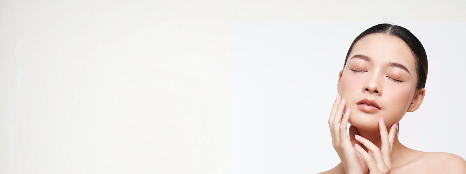 Woman with smooth skin touching her face against a light background