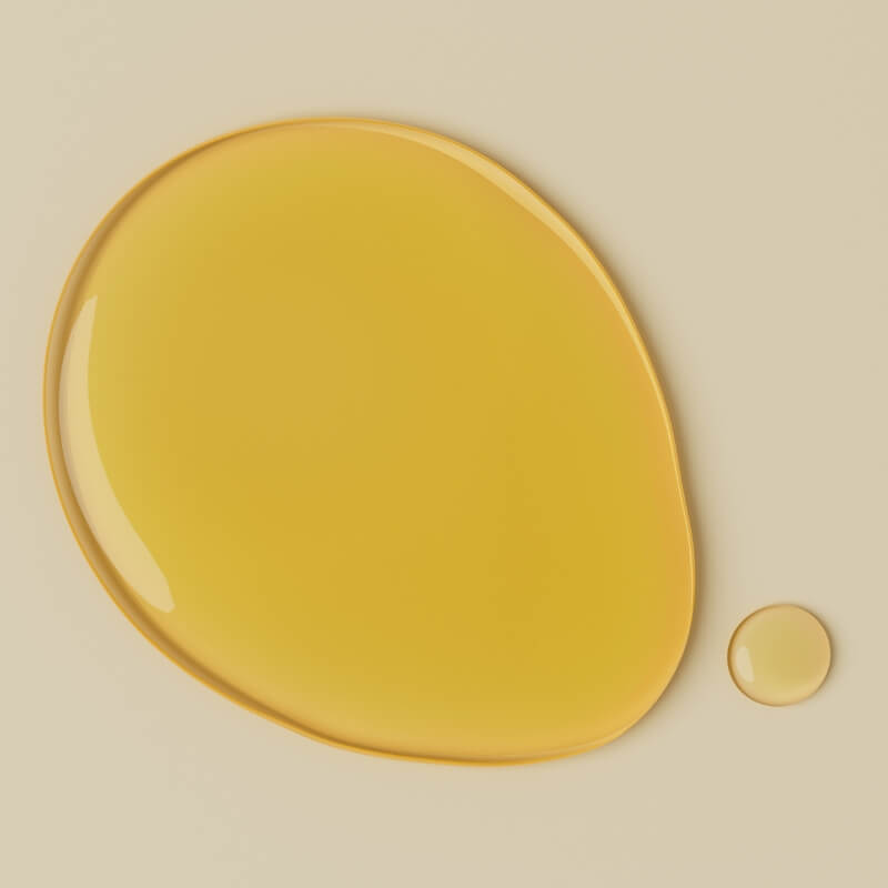 Yellow vitamin c droplets on a beige background