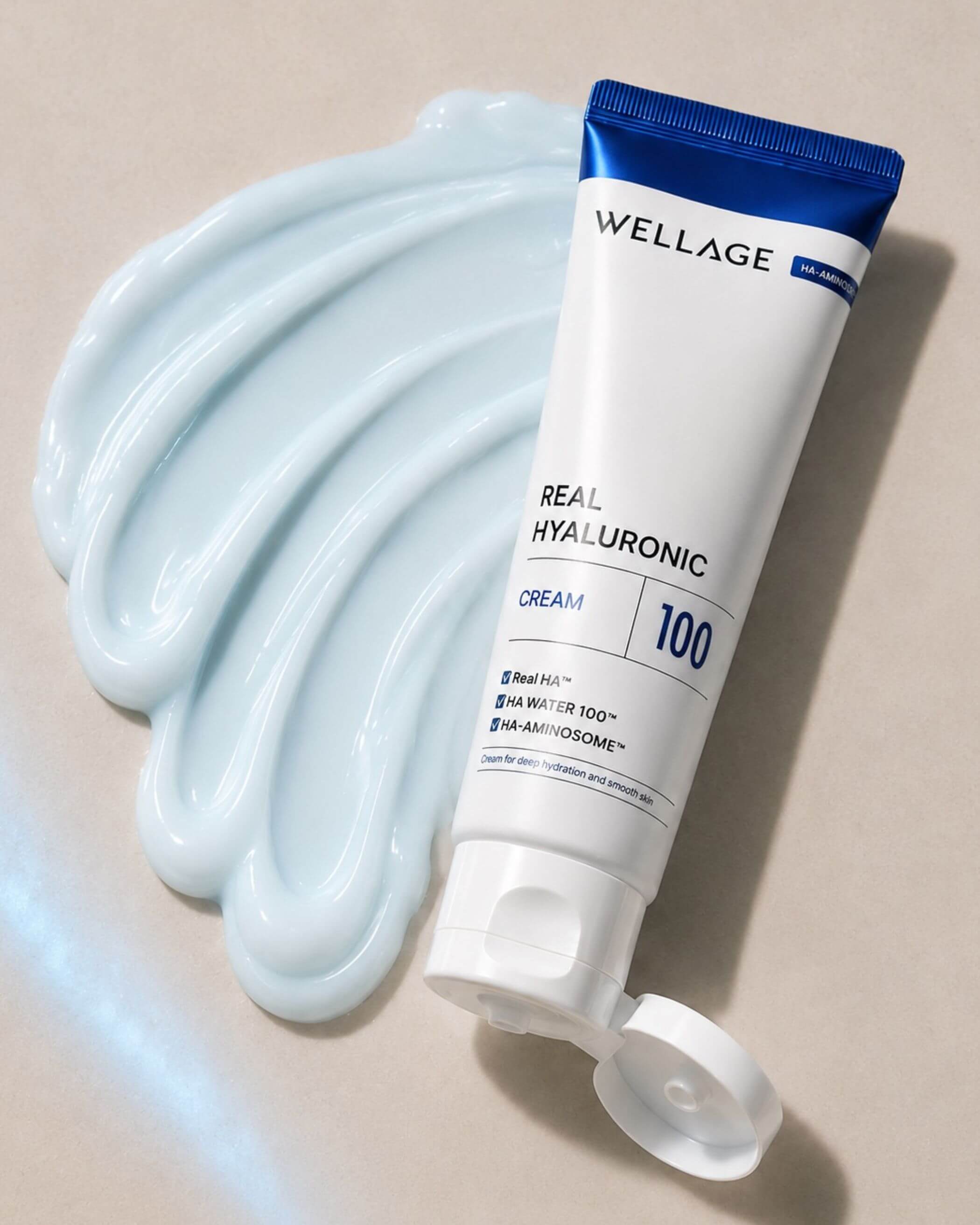 Wellage Real Hyaluronic Cream 100 tube with cream swatch on beige background